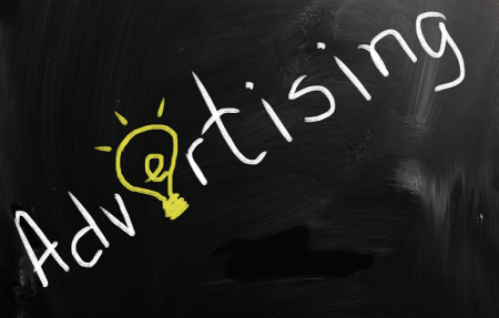Word “Advertising” written on chalkboard with a lightbulb as the letter “E”