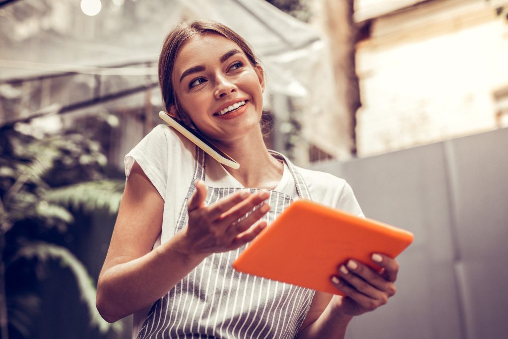Business woman smiling while talking on the phone - Our Message On Hold service is built to turn this underutilized moment into an effective, branded experience
