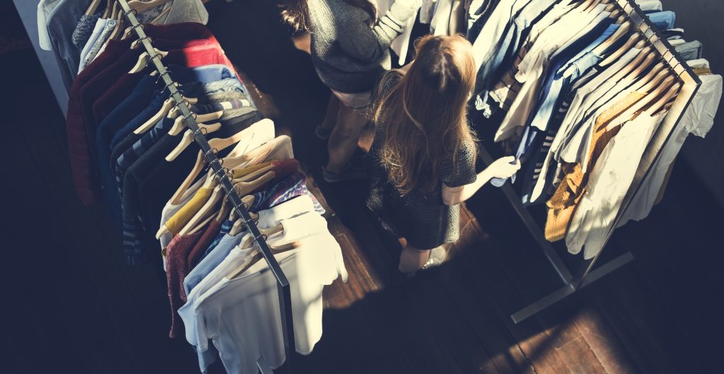 For businesses ready to break through the noise of traditional and digital media, Programmatic Audio Out-of-Home provides a pathway to connect with Canadians in a meaningful, memorable way. - Overhead shot of people shopping in a clothing store.